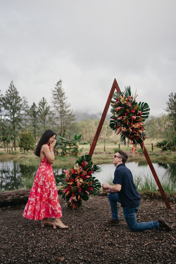 Frank proposing to Osiris under a tropical flower arch overlooking Arenal